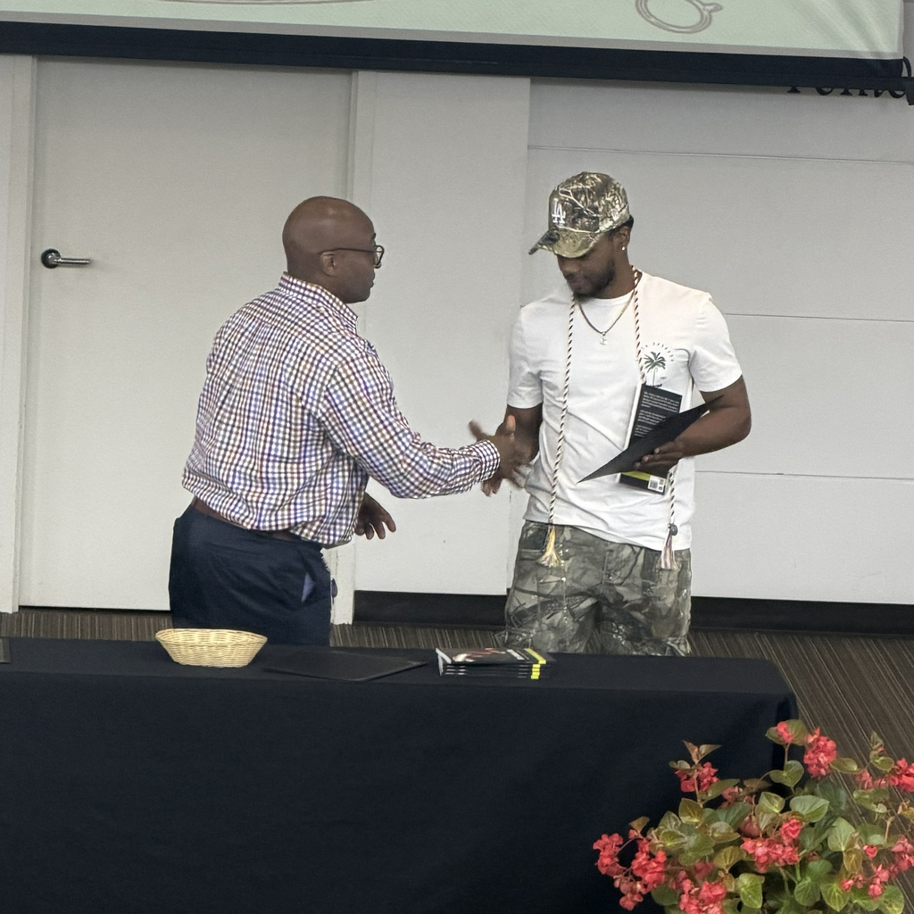 Man shaking hand with student holding certificate.