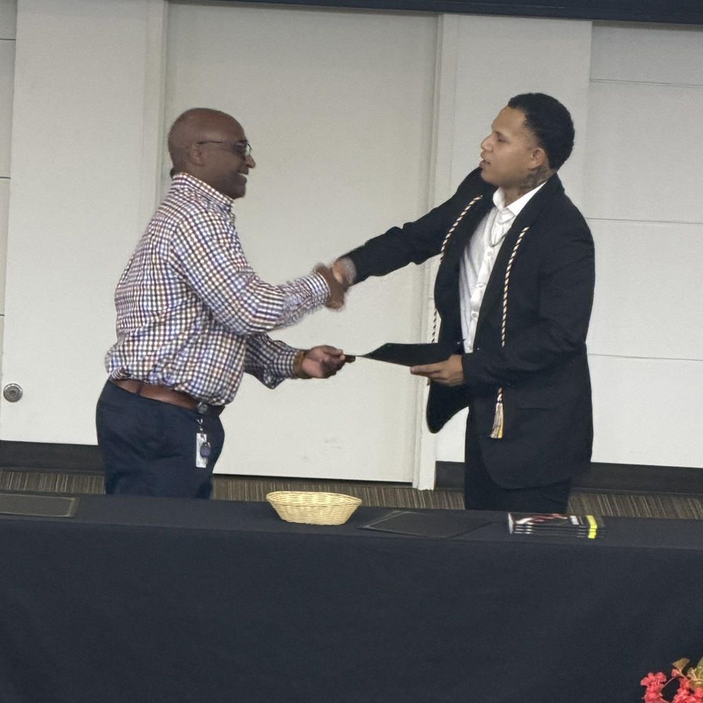 Man shaking hand with student holding certificate.