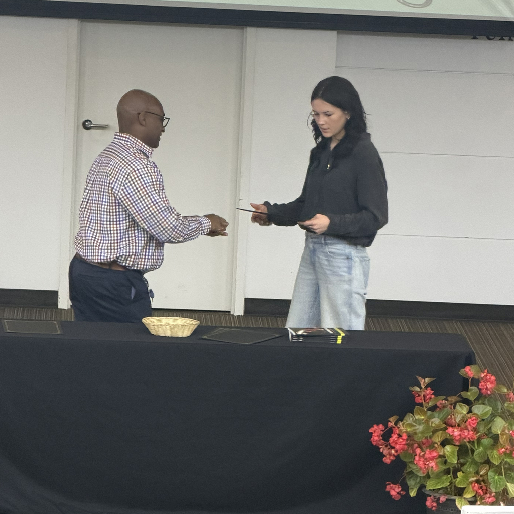 Man shaking hand with student holding certificate.