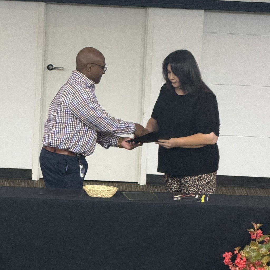 Man shaking hand with student holding certificate.
