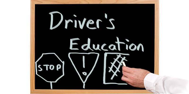 Chalk board with person writing driving symbols on it
