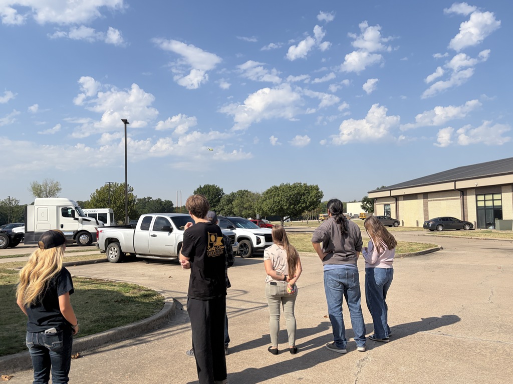 A group of students flying drones outsiide