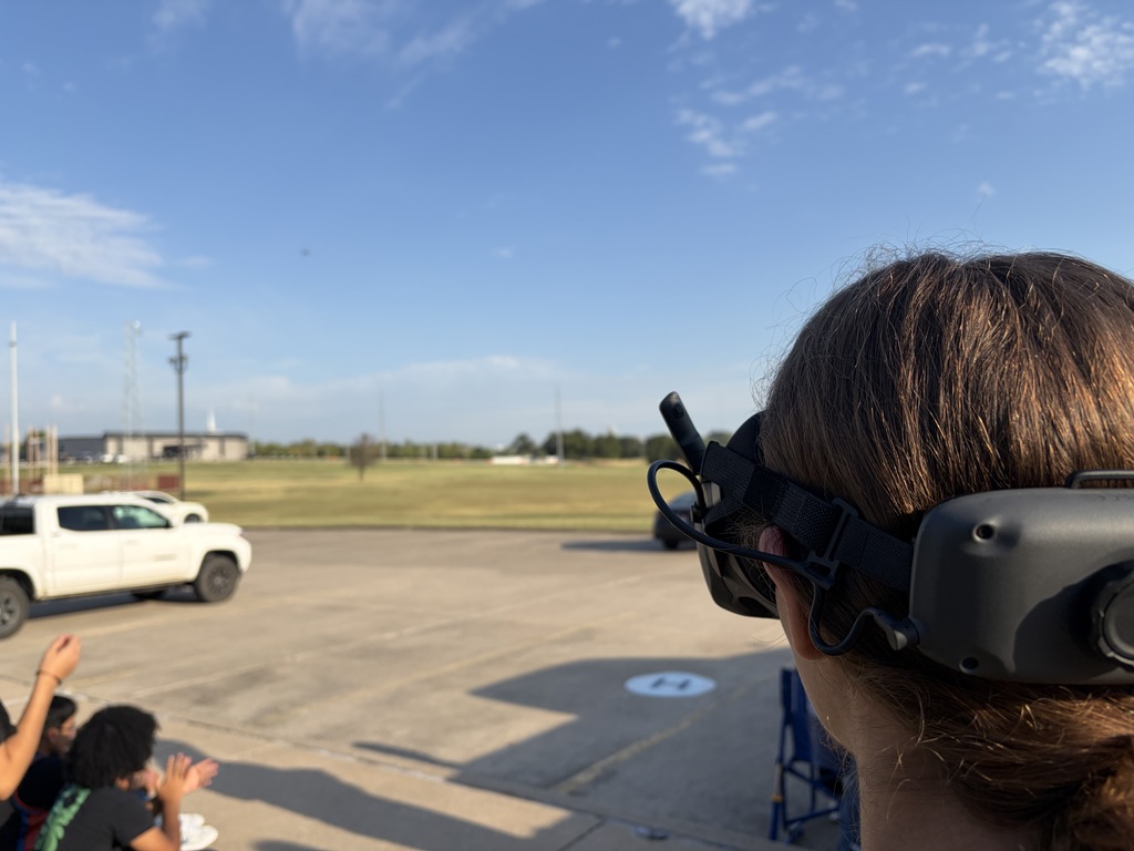 student flying a drone using a headset for visuals