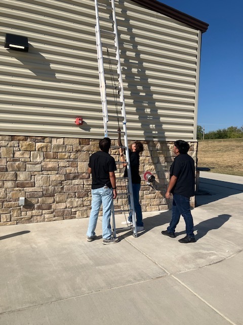 Students working with a ladder