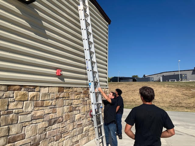 Students working with a ladder