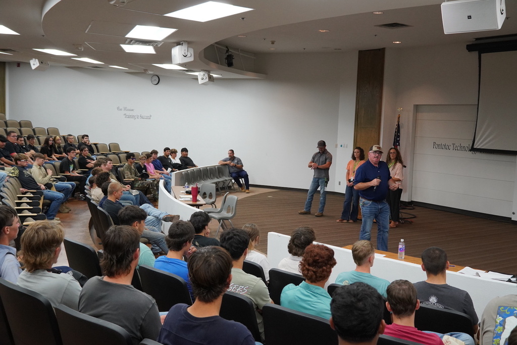Man and colleagues presenting to a group of students