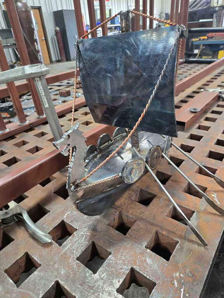 Model boat with black sail.