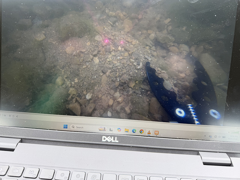 Underwater image of a drone with a claw reaching out to grab something