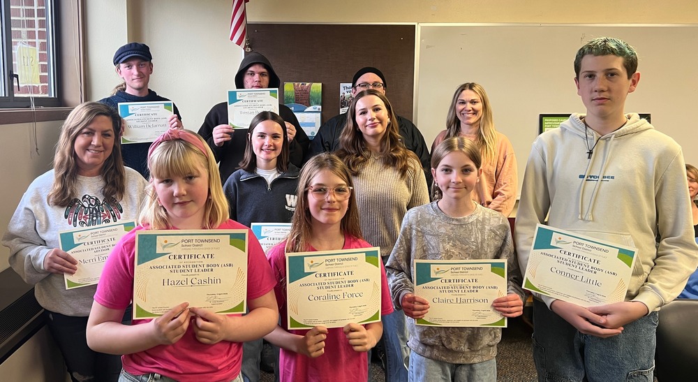 ASB students hold their certificates from the school board