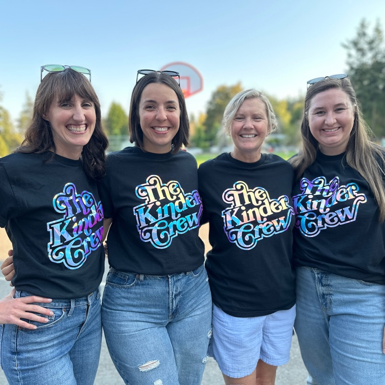 kindergarten teachers in matching t shirts smiling at back to school night.