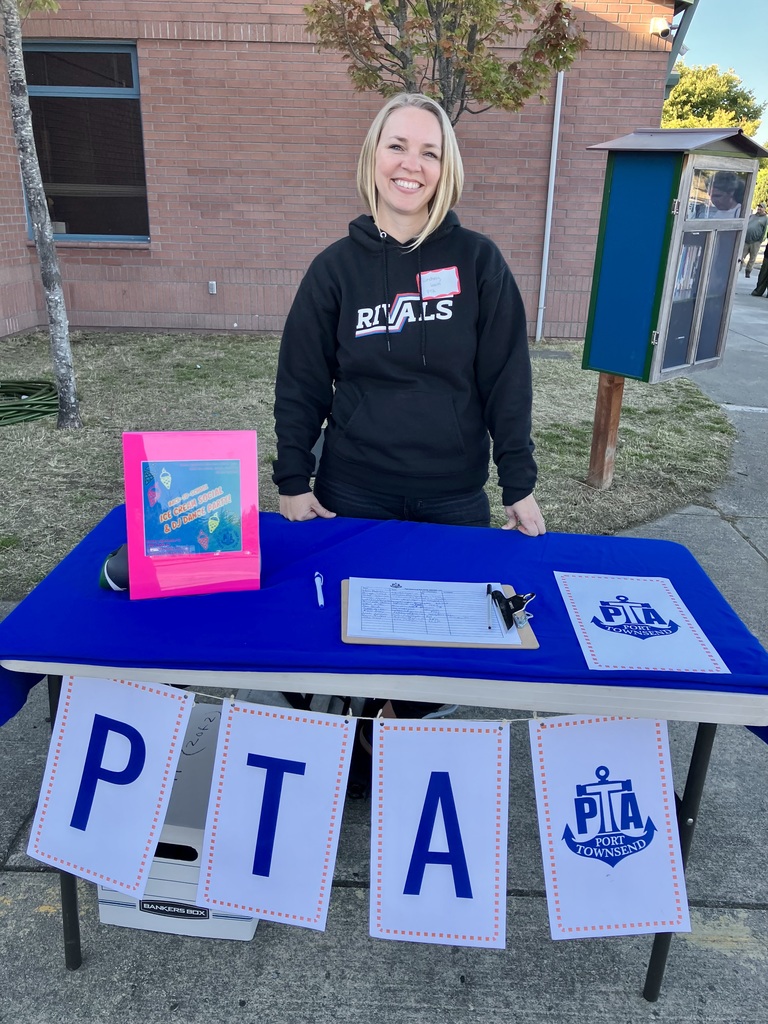 Photo of smiling woman standing at PTA table at Middle School