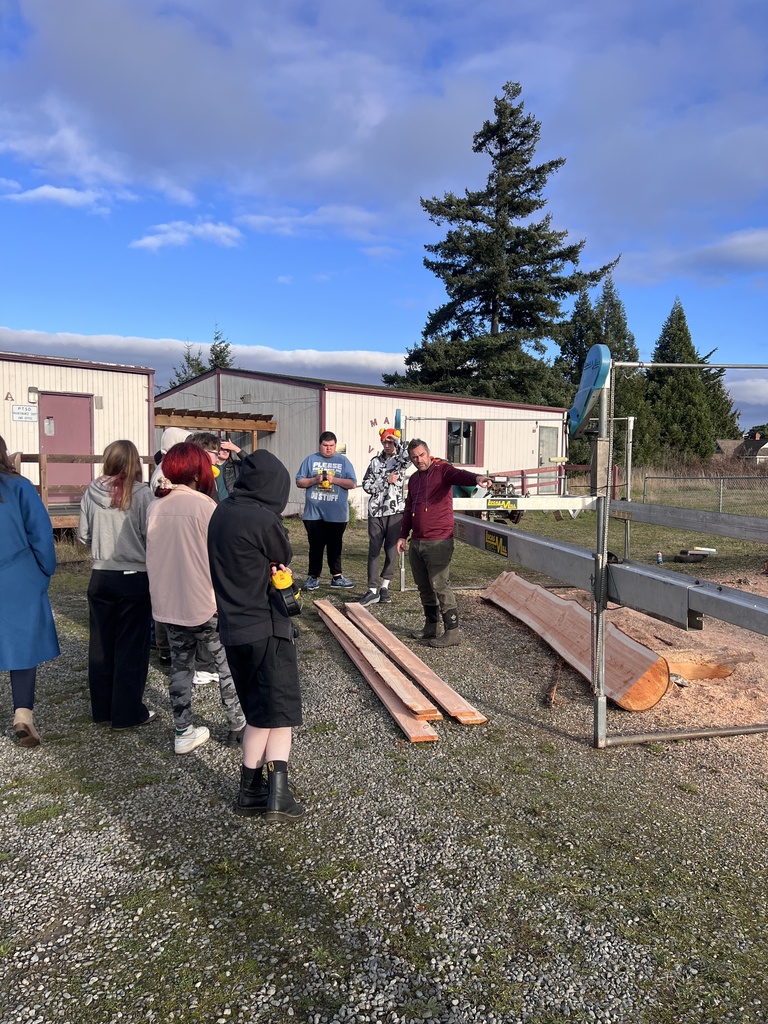 teacher showing students how to cut this wood to create a bench