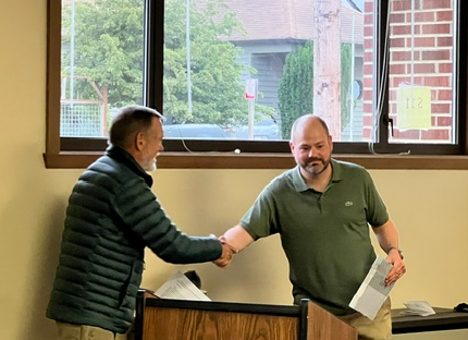 Principal Sean Moss shaking hands and recieving award