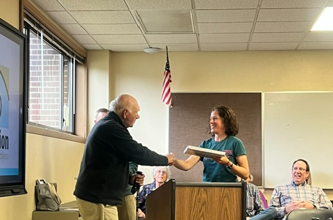 Linda Lenz and Howard shaking hands