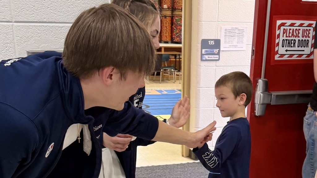 High school student high-fiving a fourth grader