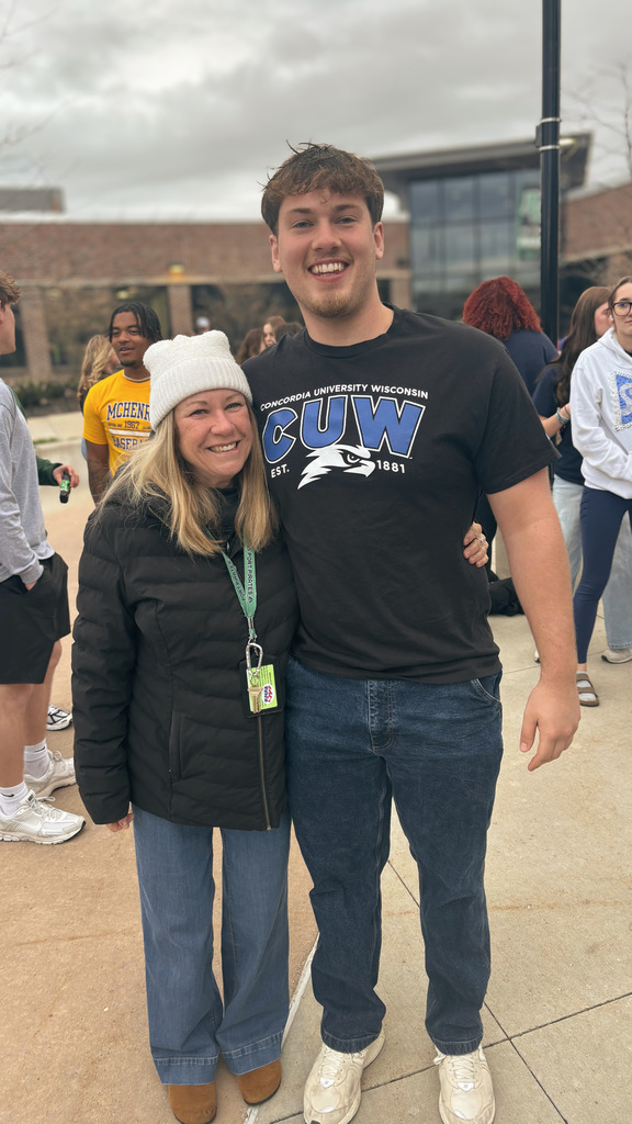 a teacher with a male student wearing a concordia university wisconsin tshirt