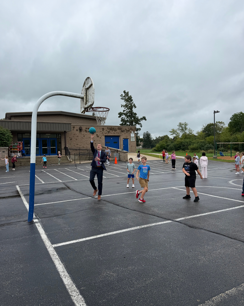 Students and Superintendent playing basketball on playground