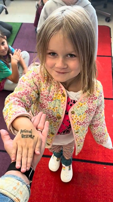 A student hand with Animal Rescuer written on it
