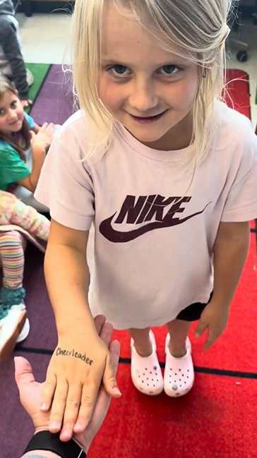 A student hand with Cheerleader written on it