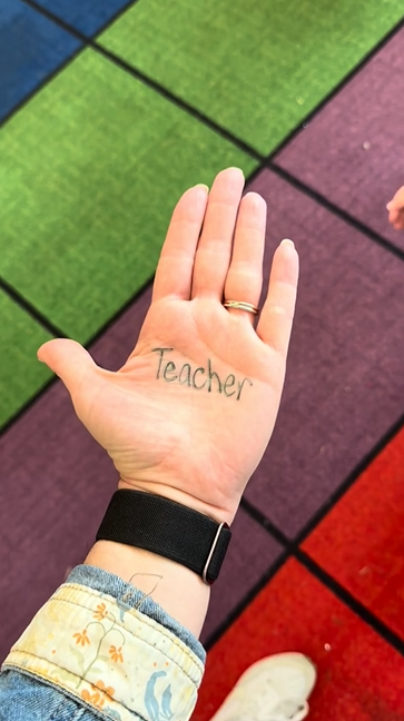 A teacher hand with Teacher written on it