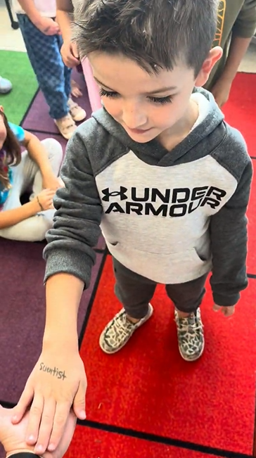A student hand with Scientist written on it