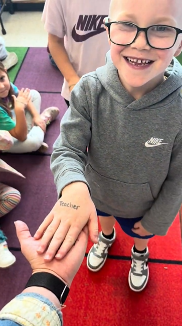 A student hand with Teacher written on it