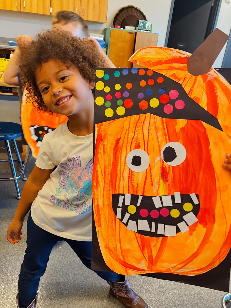 Student Holding Kindergarten Pumpkin Artwork