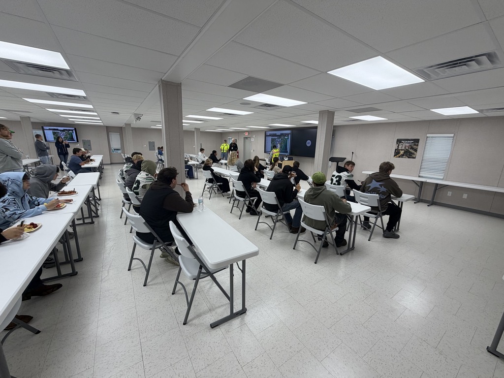 Students enjoying a breakfast and listening to safety protocols.