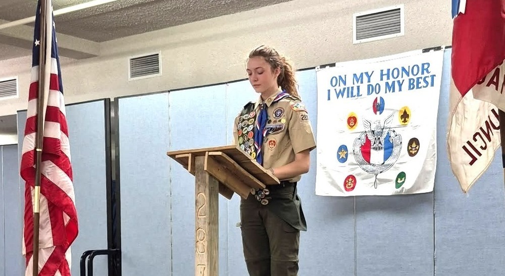 a female eagle scout standing at a podium