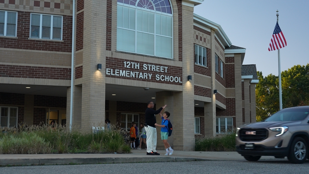 Mr. B High Fiving a Student OutFront of 12th Street Elementary