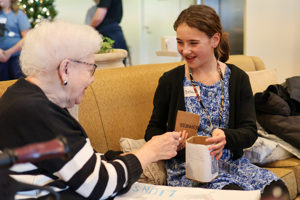 a girl presents a project to an elderly woman