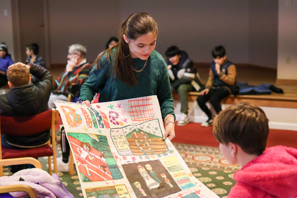 a young student shows off a poster project