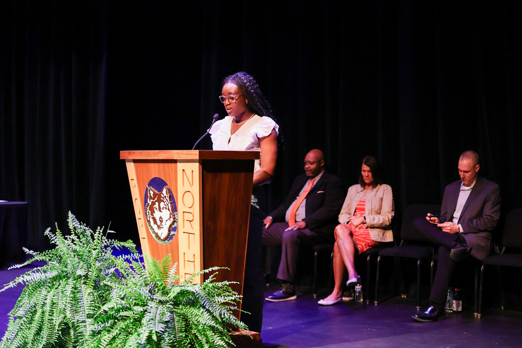a girl speaks at a podium on stage