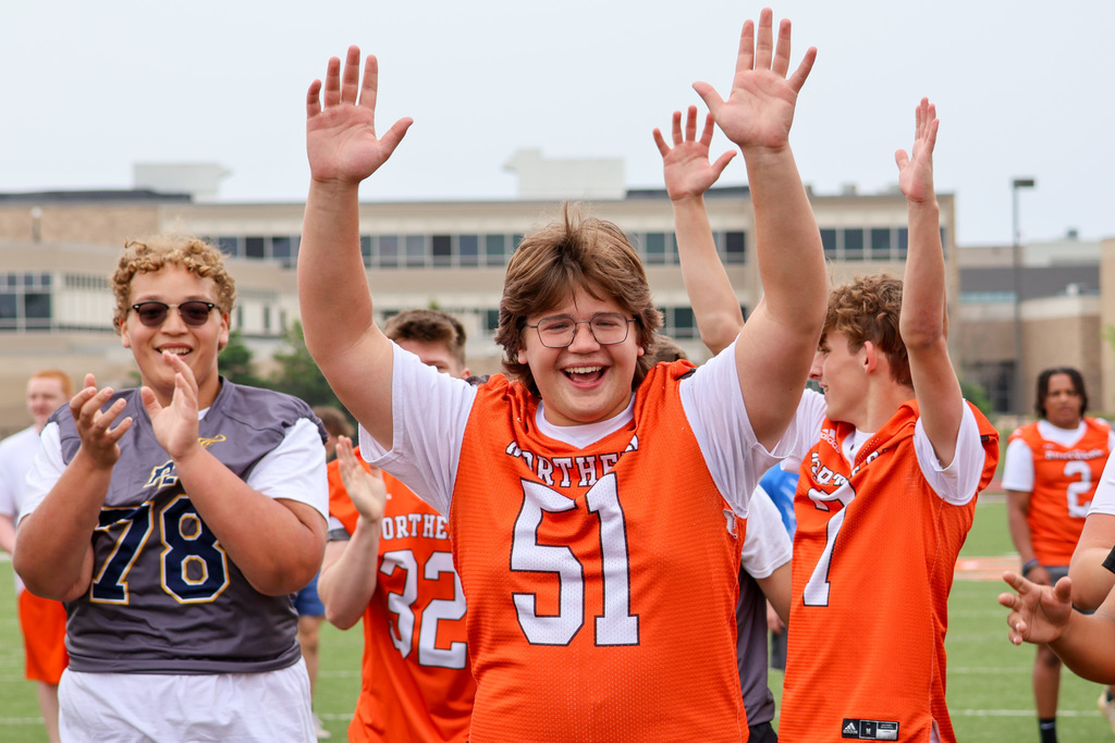 a group of boys cheer on a football field