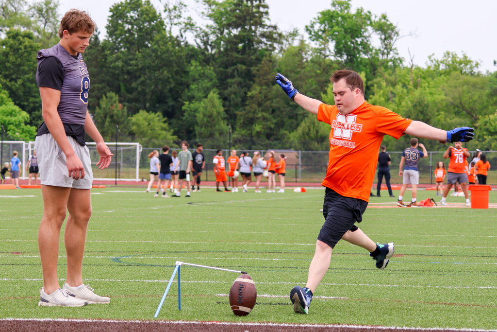 a boy kicks a football on a football field