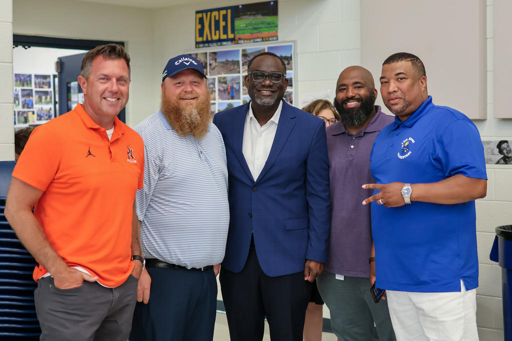 five men pose for a photo together