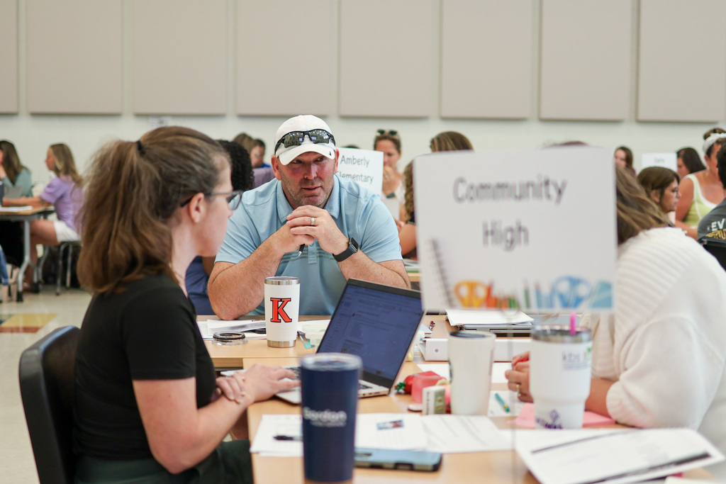 a man listens at a table with others