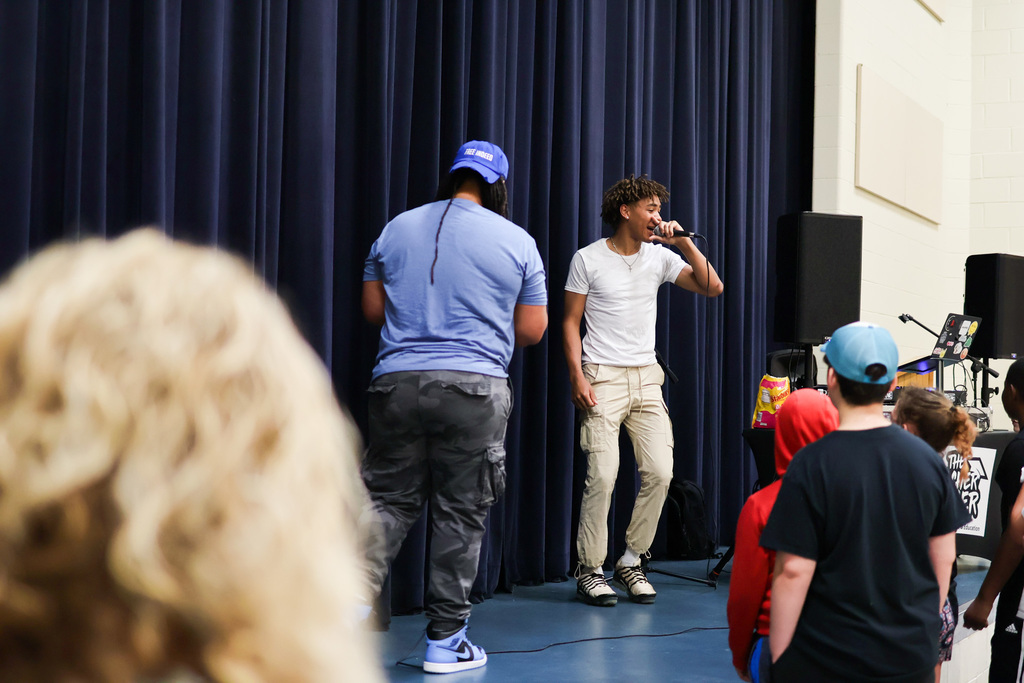 two rappers perform in front of students
