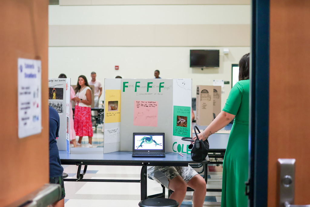a presentation on frogs seen through the doorway of a school cafeteria