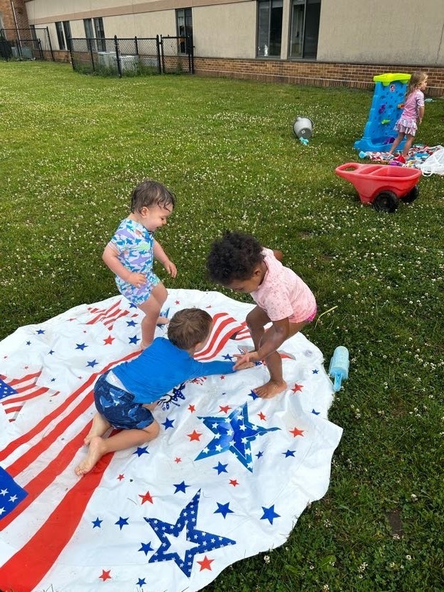Three toddlers playing on a water lily pad.