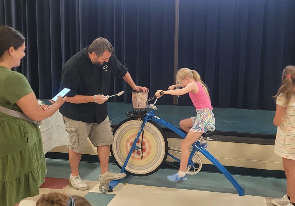 an elementary age girl mixes a smoothie with a bike