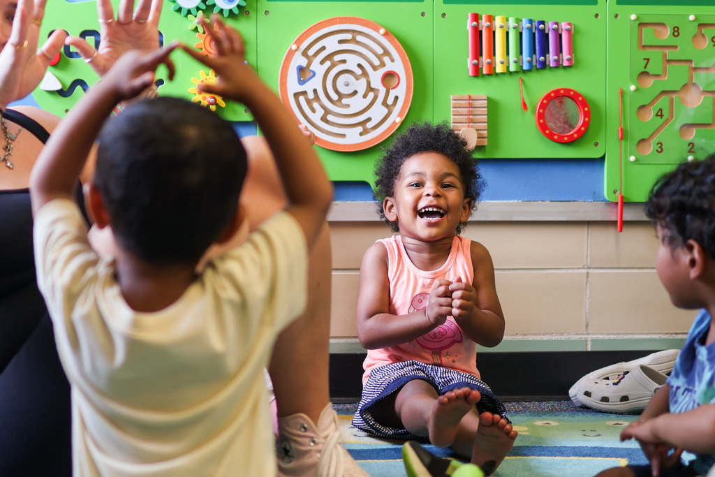 a young girl smiles big inside a classroom