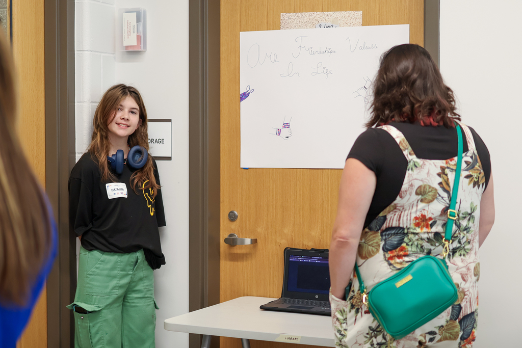 a girl poses for a photo next to her poster