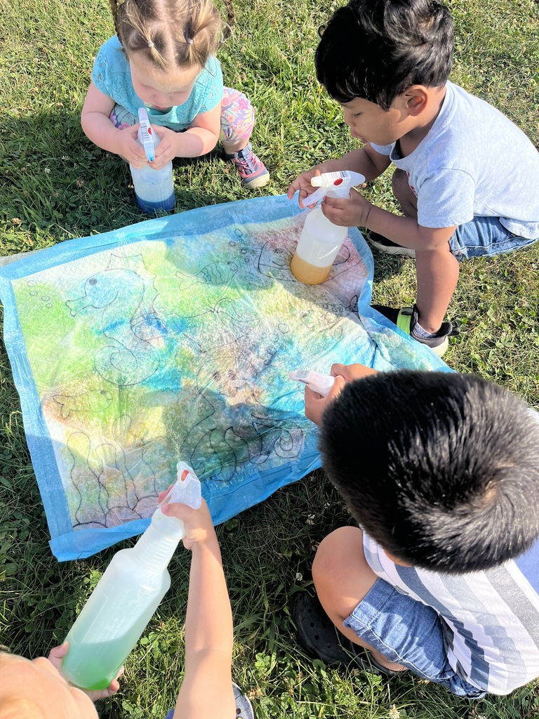 painting sea animals with spray bottles outside.