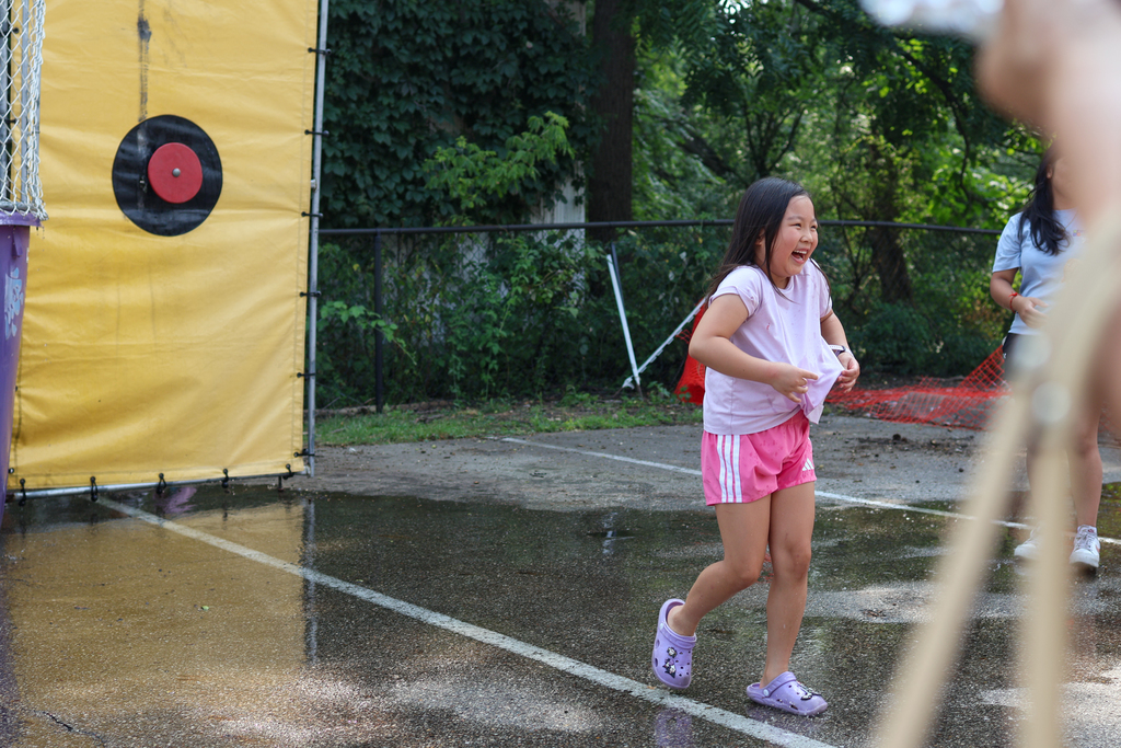 a little girl all wet walking away from a dunk tank