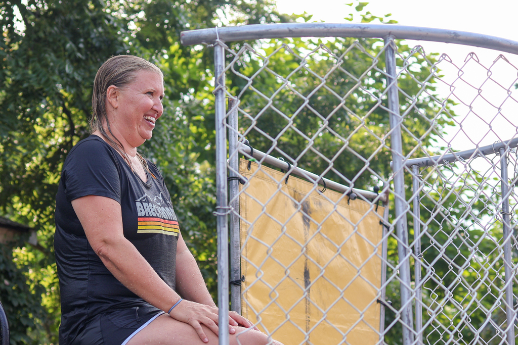 a woman all wet sitting in a dunk tank 