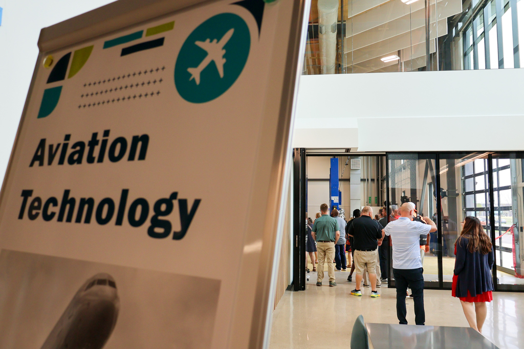 people walk into a classroom labeled aviation technology