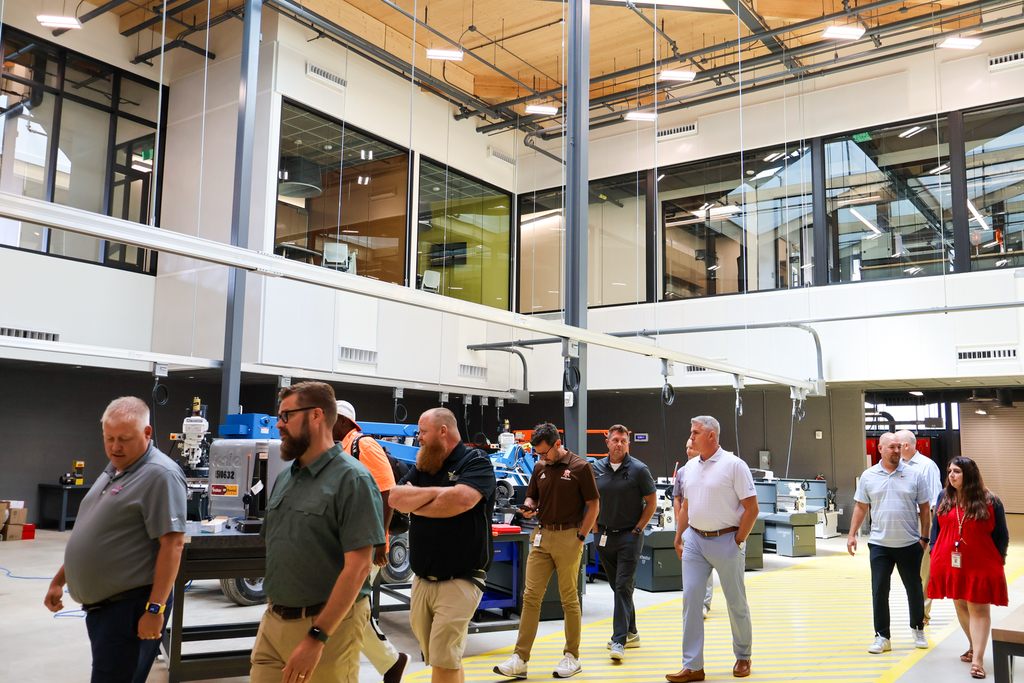 a group of people walk through a large career center