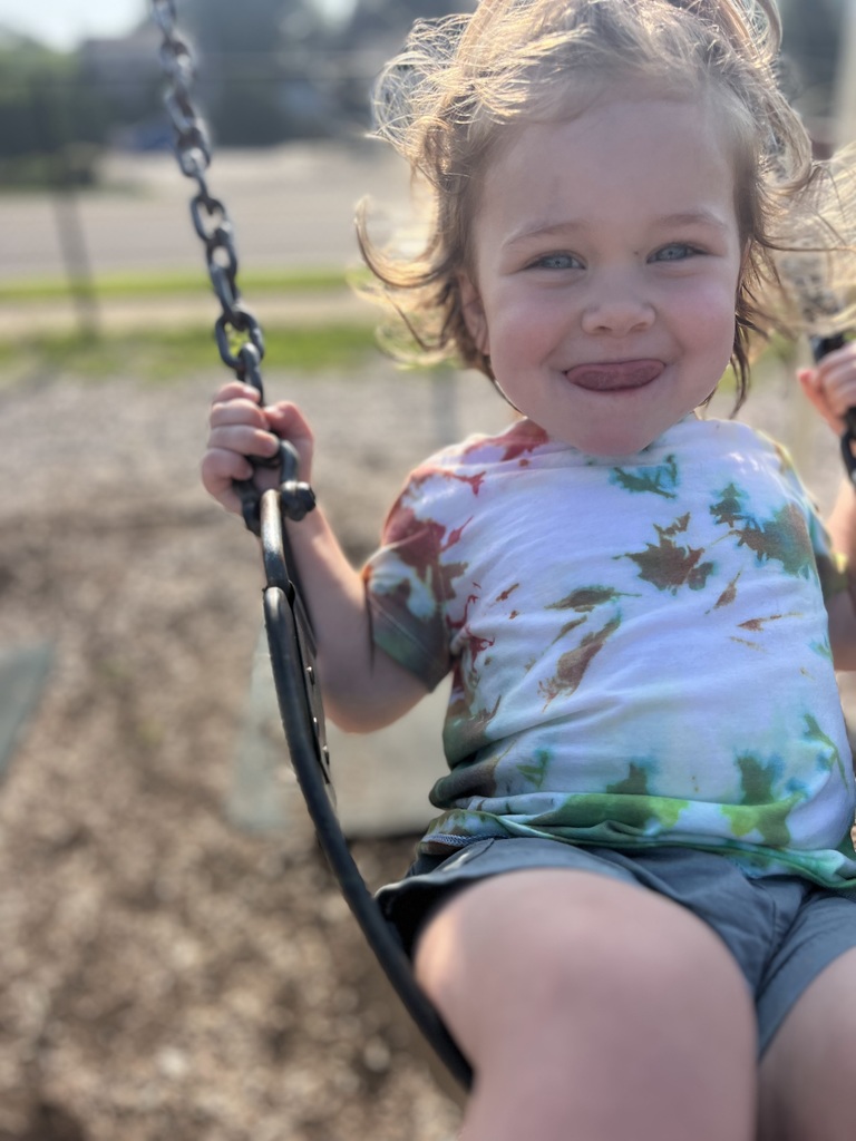 Boy swinging with a smile.