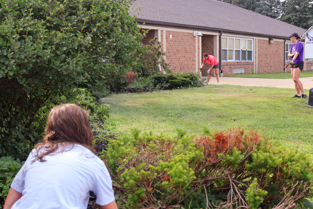 multiple women garden outside an elementary school